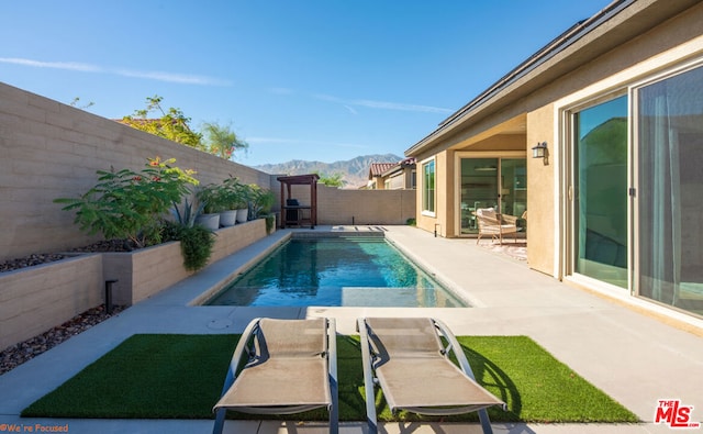 view of swimming pool with a mountain view and a patio