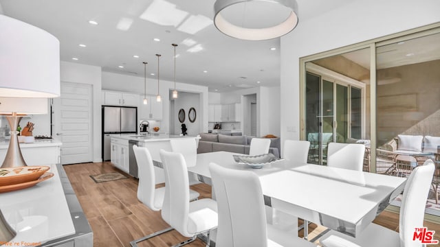 dining area with sink and light hardwood / wood-style floors