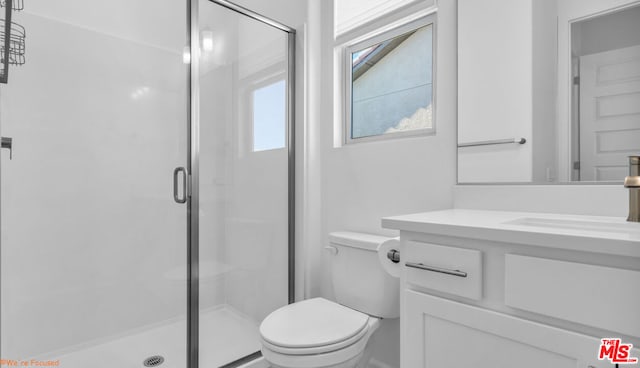 bathroom featuring vanity, toilet, and walk in shower