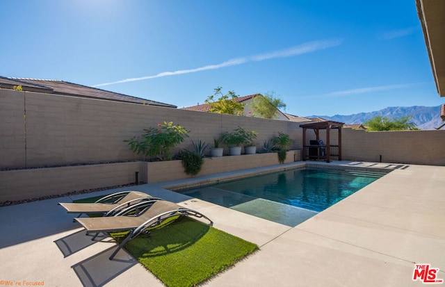 view of swimming pool featuring a gazebo, a mountain view, and a patio area