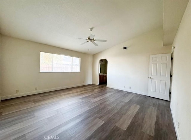 spare room with dark hardwood / wood-style floors, ceiling fan, and vaulted ceiling