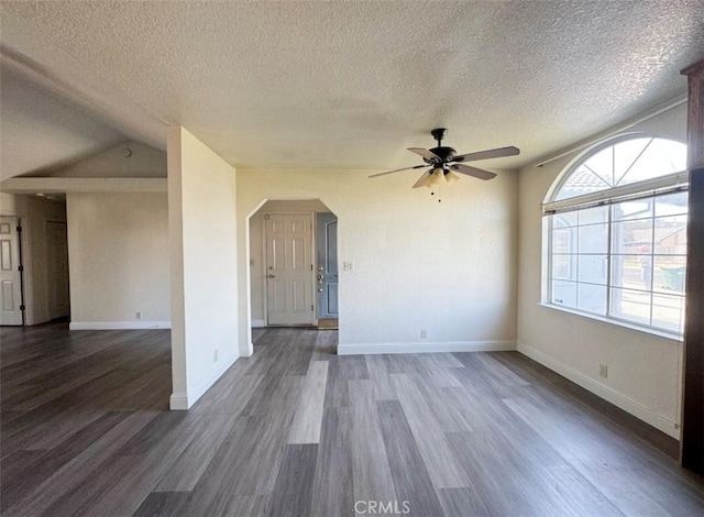 spare room featuring a textured ceiling, dark hardwood / wood-style flooring, ceiling fan, and lofted ceiling