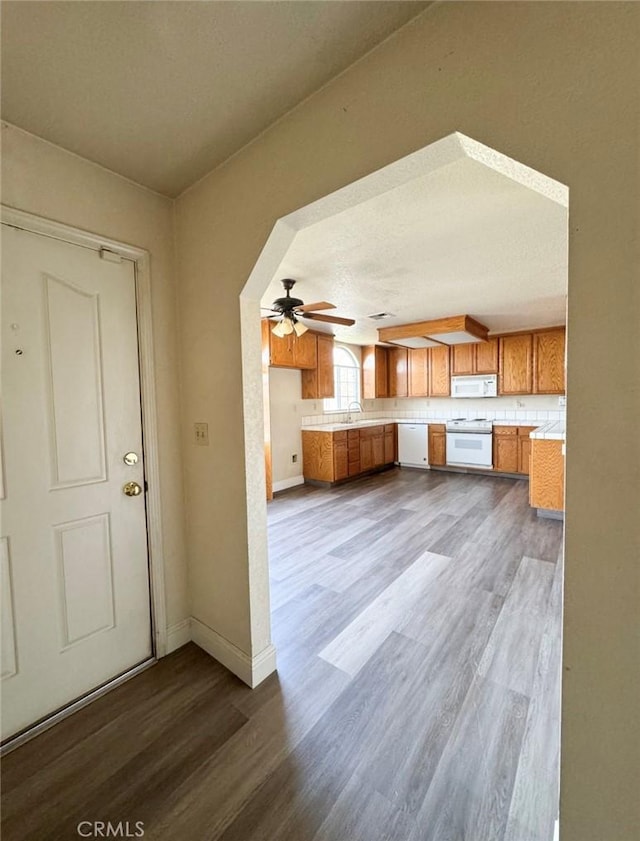 kitchen with white appliances, a textured ceiling, ceiling fan, sink, and hardwood / wood-style floors