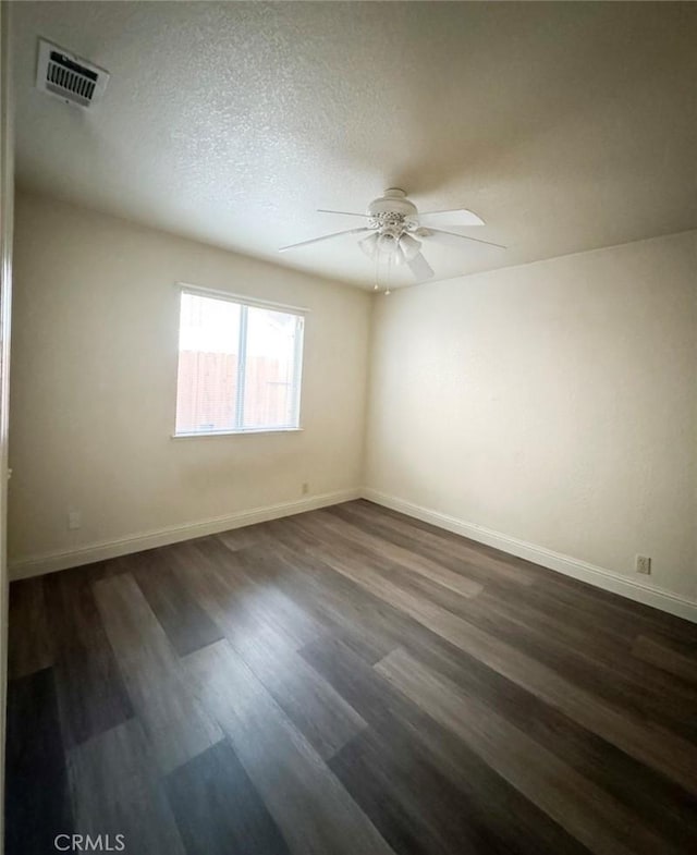 spare room featuring a textured ceiling, dark hardwood / wood-style floors, and ceiling fan