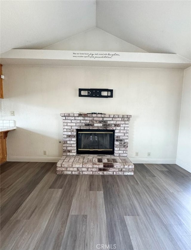 unfurnished living room featuring a fireplace, dark hardwood / wood-style floors, and vaulted ceiling