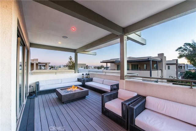 deck at dusk featuring an outdoor living space with a fire pit