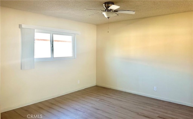 empty room with hardwood / wood-style flooring, ceiling fan, and a textured ceiling