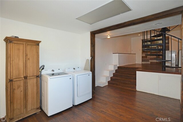 laundry room with washer and clothes dryer, cabinets, and dark hardwood / wood-style floors