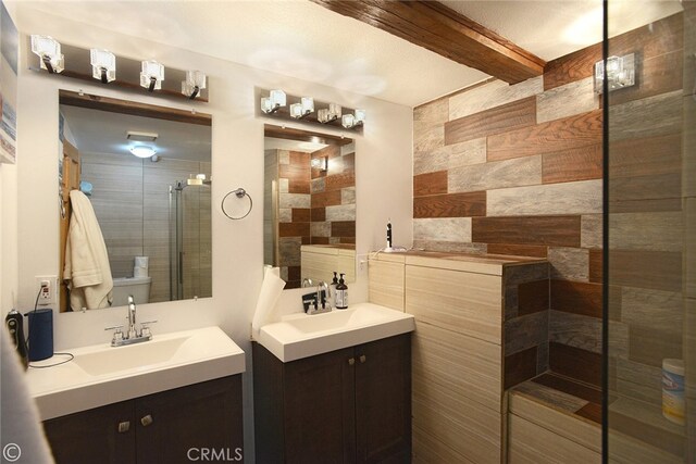 bathroom featuring vanity, a shower with shower door, and tile walls