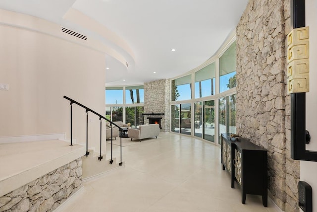 interior space with a stone fireplace and expansive windows