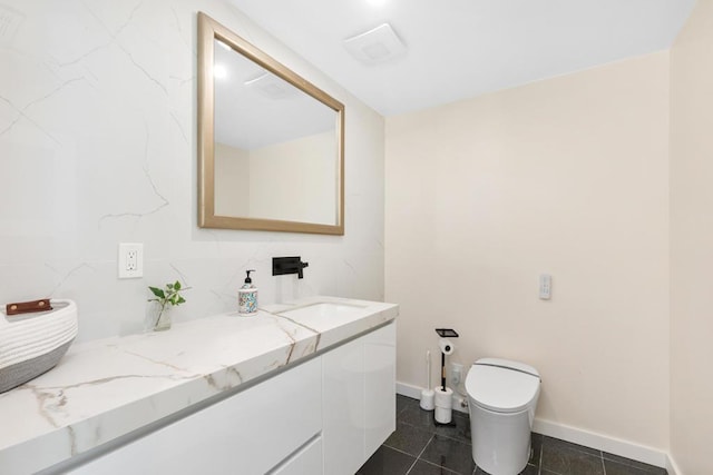 bathroom featuring tile patterned flooring, vanity, and toilet