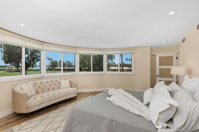 bedroom with light hardwood / wood-style floors and multiple windows