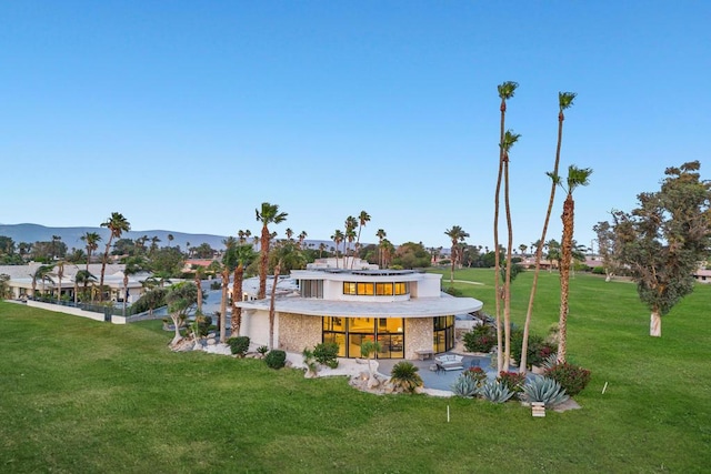 exterior space featuring a mountain view, a yard, and a balcony