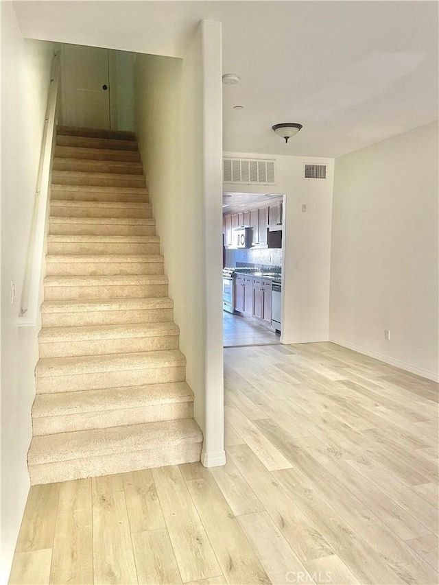 stairway with hardwood / wood-style flooring