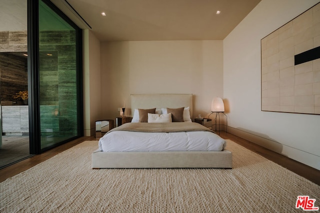 bedroom with wood-type flooring and access to outside