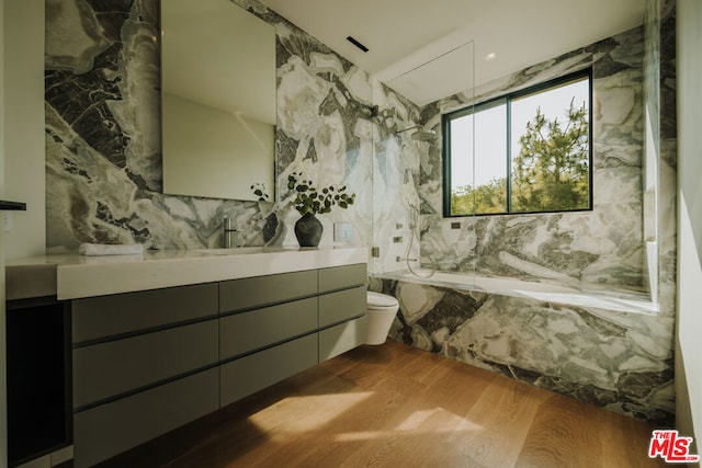 bathroom featuring a bathing tub, vanity, toilet, and wood-type flooring