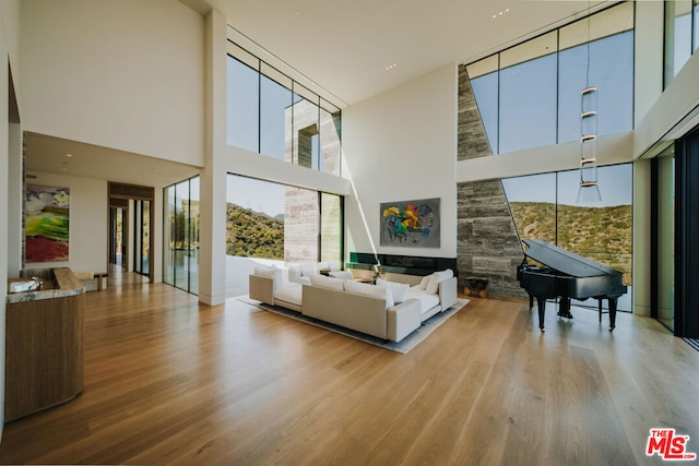 living room with light wood-type flooring and a towering ceiling