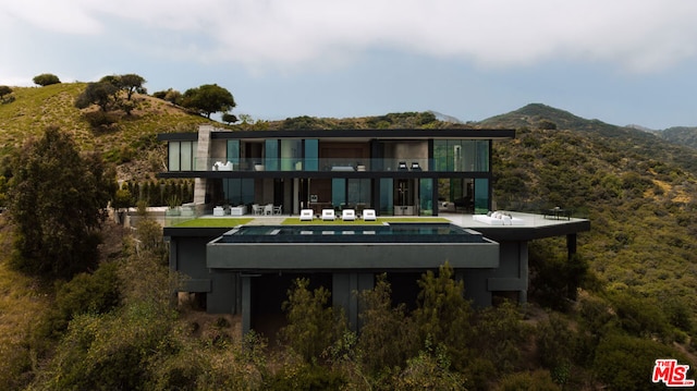 back of property featuring a mountain view and a patio area