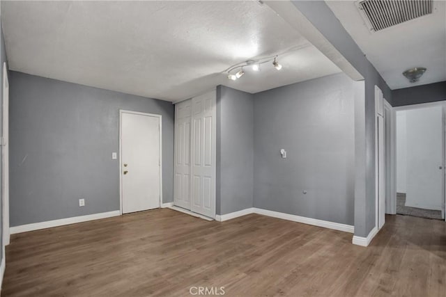 interior space with visible vents, baseboards, and wood finished floors