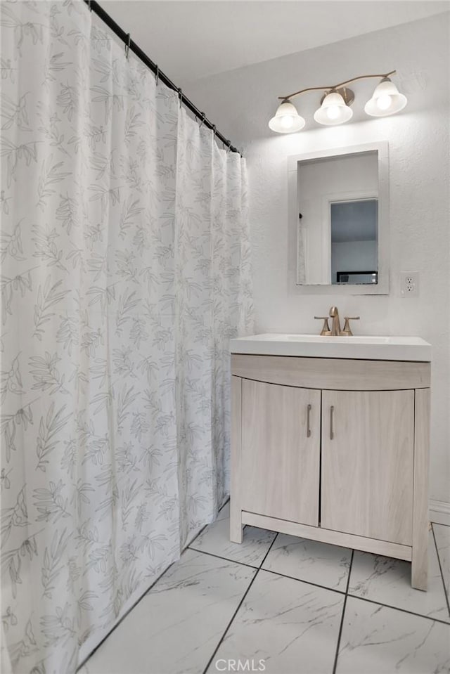 full bath featuring marble finish floor and vanity