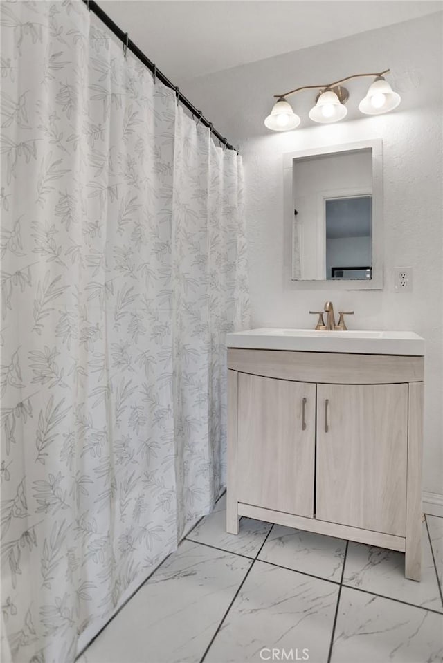 bathroom featuring marble finish floor and vanity