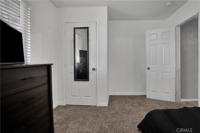 carpeted bedroom featuring baseboards and multiple windows