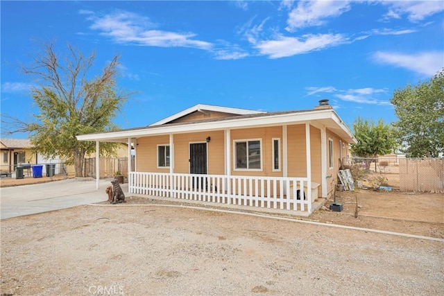 10590 Navajo Rd, Apple Valley, CA 92308 - view of front of house with a porch, fence, driveway, and a chimney