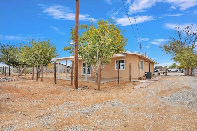 view of property exterior with a patio, stucco siding, and central air condition unit