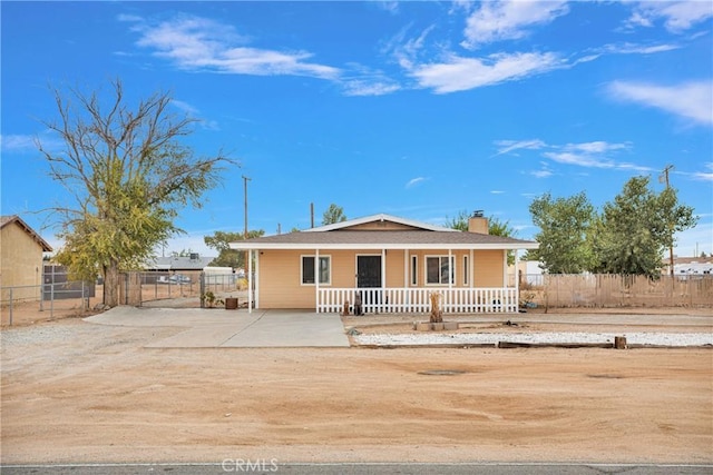 10590 Navajo Rd, Apple Valley, CA 92308 - view of front facade featuring covered porch, a chimney, and fence