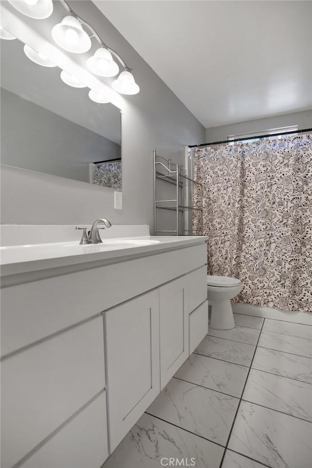 full bath featuring marble finish floor, a shower with shower curtain, vanity, and toilet