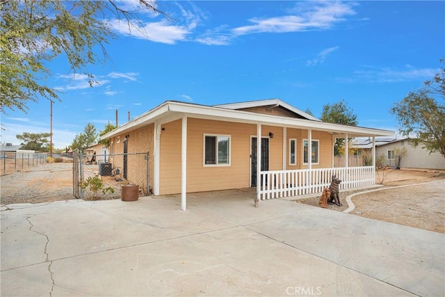 view of front of home with fence, covered porch, cooling unit, and a gate