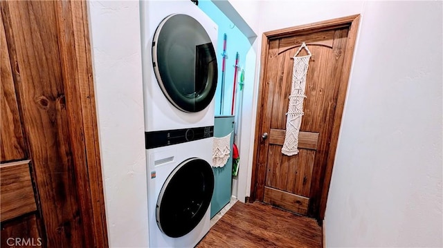 washroom with dark hardwood / wood-style floors and stacked washer / dryer