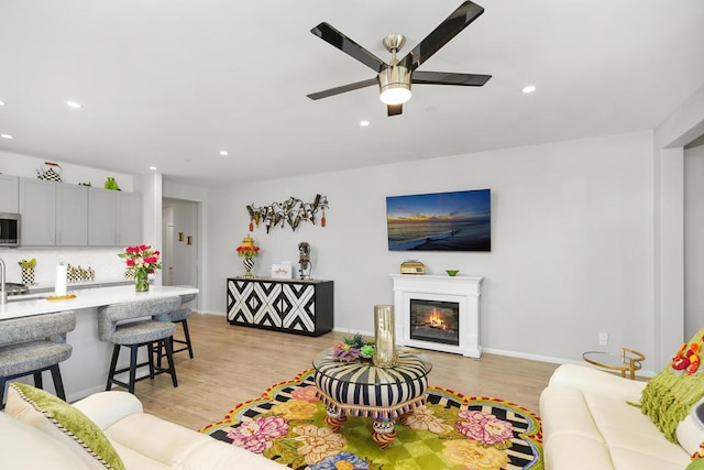 living room with ceiling fan and light hardwood / wood-style floors