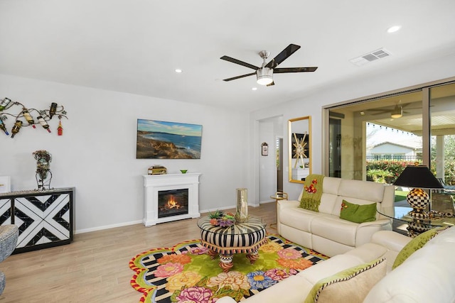 living room featuring light hardwood / wood-style flooring and ceiling fan