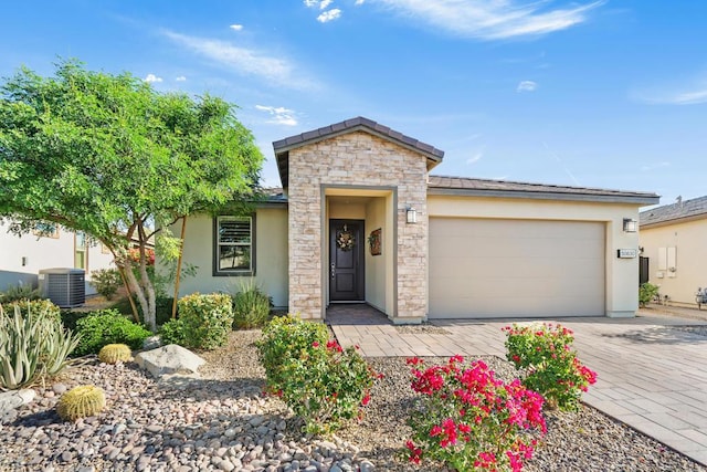 view of front of property with a garage and central AC unit