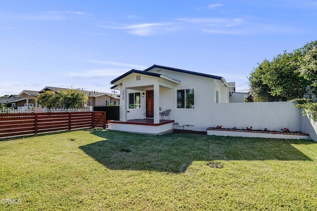 rear view of property featuring a lawn