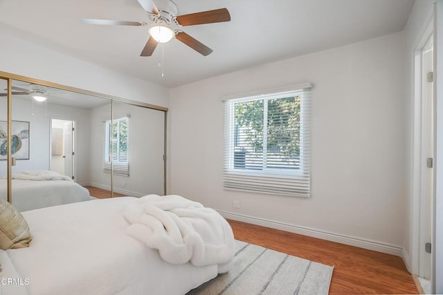 bedroom featuring a closet, light hardwood / wood-style floors, and ceiling fan