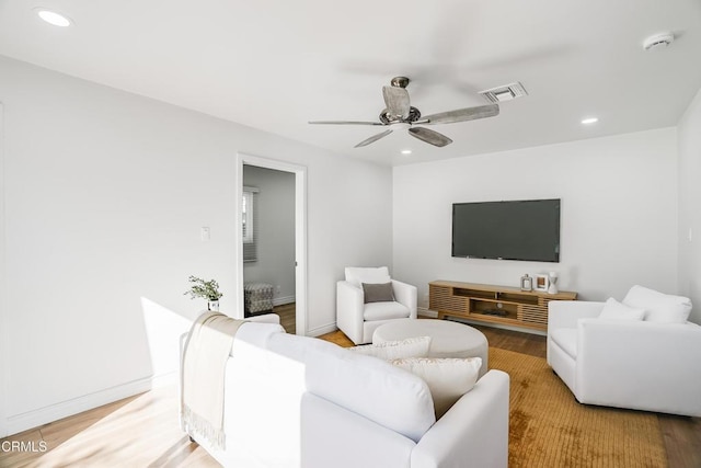 living room featuring ceiling fan and light hardwood / wood-style floors