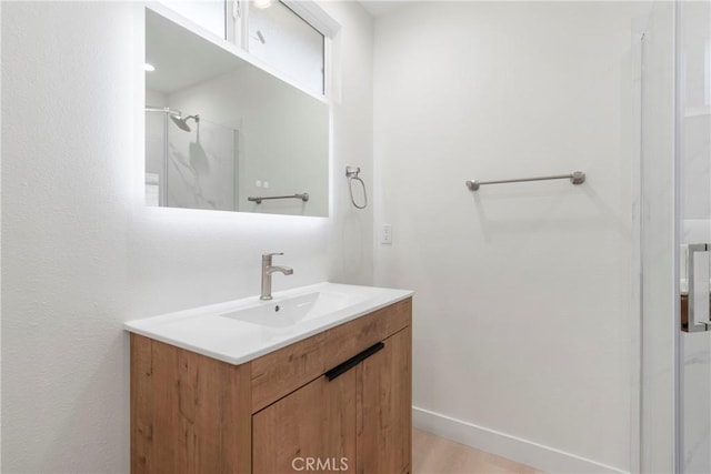 bathroom featuring walk in shower and vanity