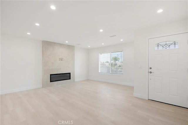 unfurnished living room with light hardwood / wood-style flooring and a fireplace