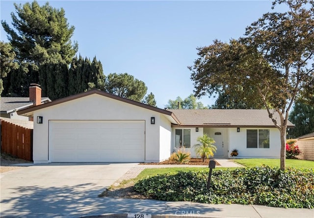 ranch-style house featuring a garage and a front lawn