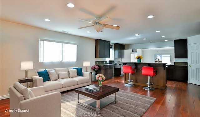 living room featuring ceiling fan, dark hardwood / wood-style flooring, and sink