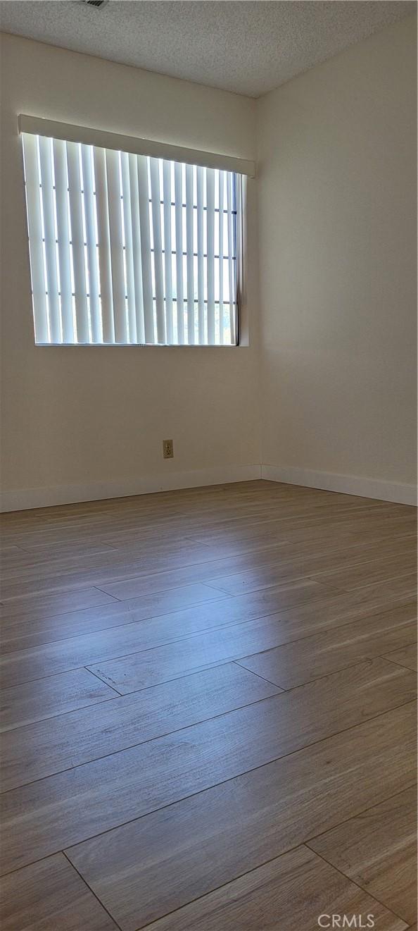 spare room featuring a textured ceiling and hardwood / wood-style flooring