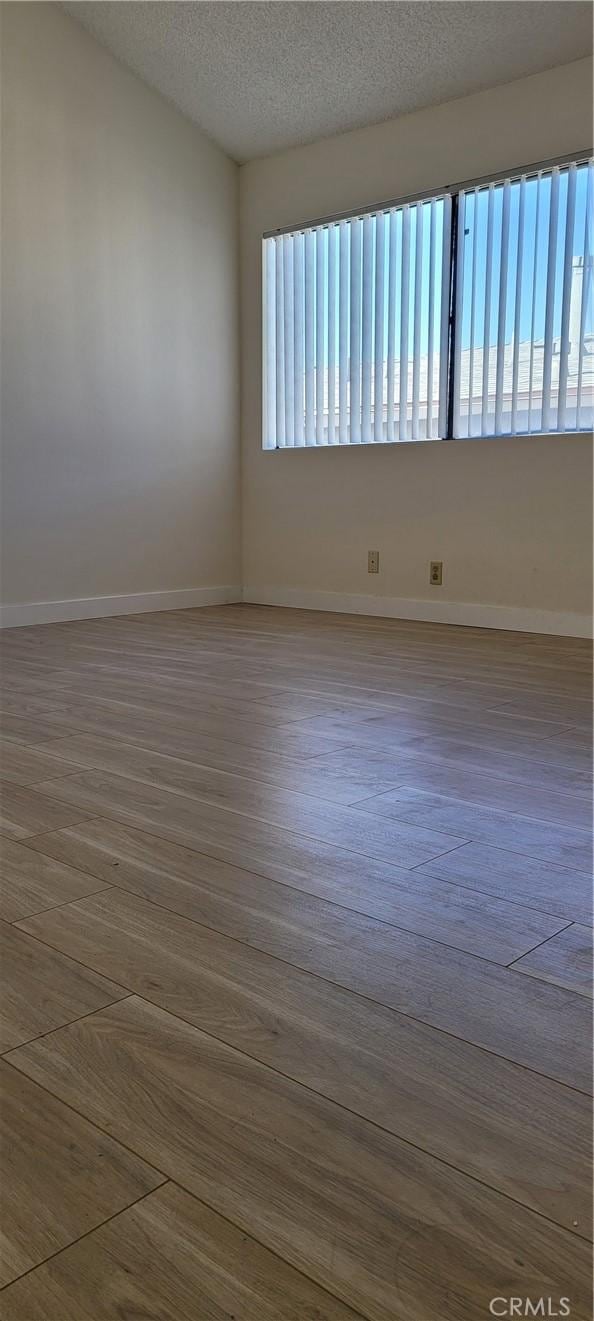 unfurnished room featuring hardwood / wood-style floors and a textured ceiling