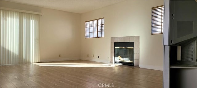 905 S 2nd St Unit D, Alhambra, CA 91801 - unfurnished living room with wood finished floors, a fireplace, and a textured ceiling