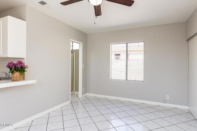 spare room featuring ceiling fan and light tile patterned floors