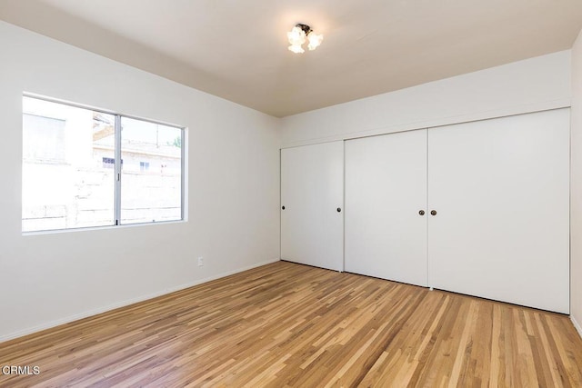 unfurnished bedroom with light hardwood / wood-style floors and a closet