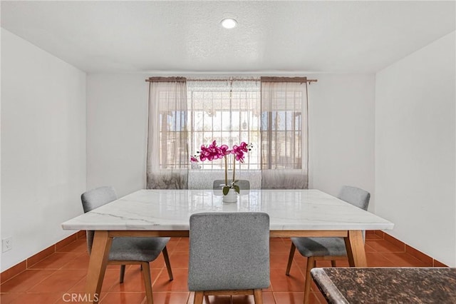 tiled dining area featuring a textured ceiling