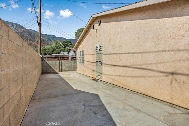 view of home's exterior with a mountain view and a patio area