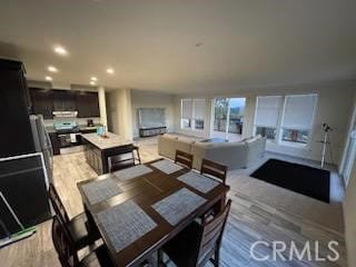 dining space with light wood finished floors and recessed lighting